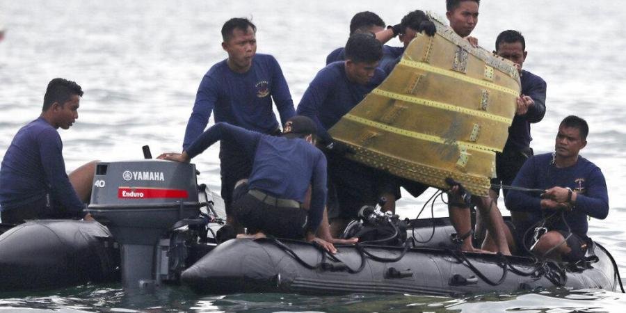 Indonesian Navy divers pull out a part of an airplane out of the water during a search operation for a Sriwijaya Air passenger jet.